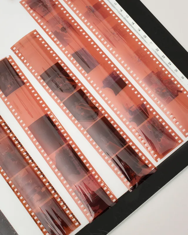 Tiras de negativos fotográficos junto a una regla de medición